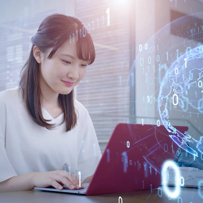 Two smiling people, a man wearing a VR headset and a woman, looking at a computer screen together